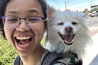 A woman with glasses and a small dog on her shoulders