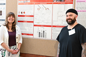 Two people flanking an academic research poster