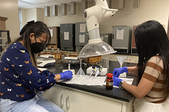 Grants high school teacher Mirasol Laberinto and Zuni Middle school teacher Ana Rosa Carmona, PhD in a laboratory